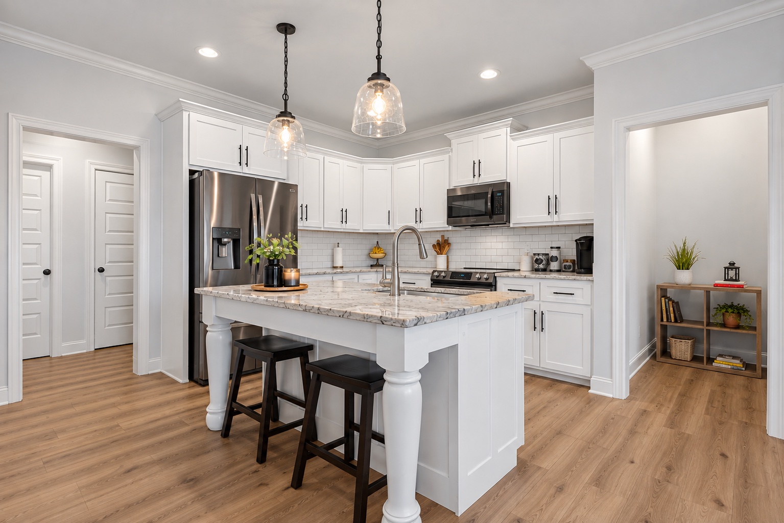 Kitchen island with seating, granite countertops and white cabinetry at 23 Cornerstone Dr